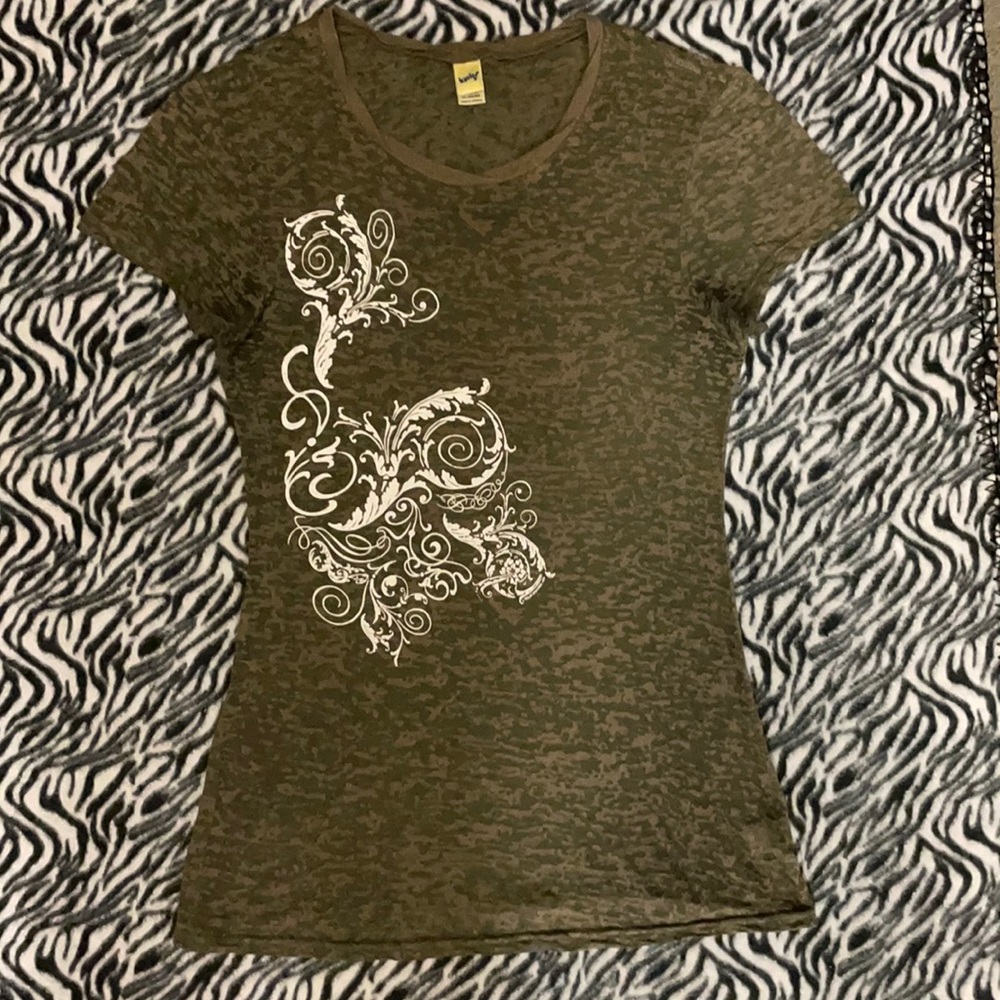 Partly sheer green shirt with a boho pattern centered mostly on the right side.